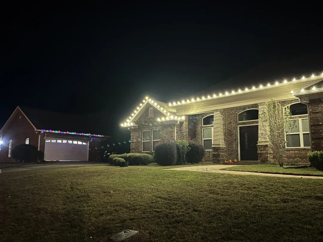 Home with lit rooflines and wrapped columns