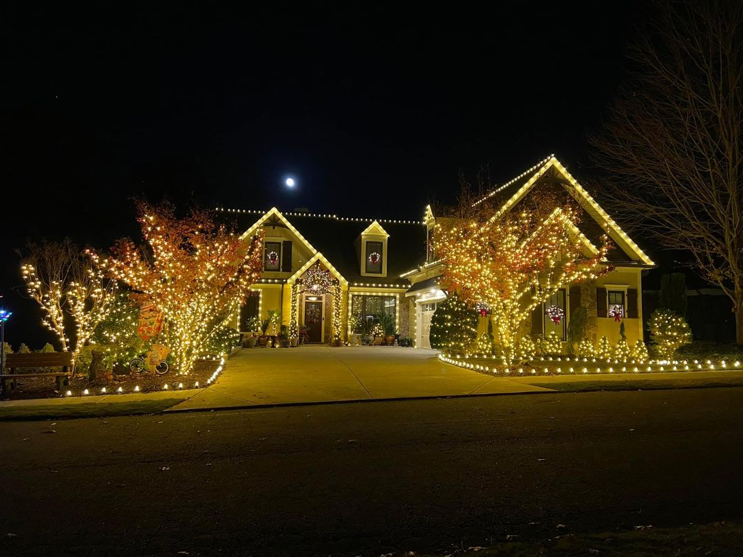 Christmas lights along the roof peaks of a brick home