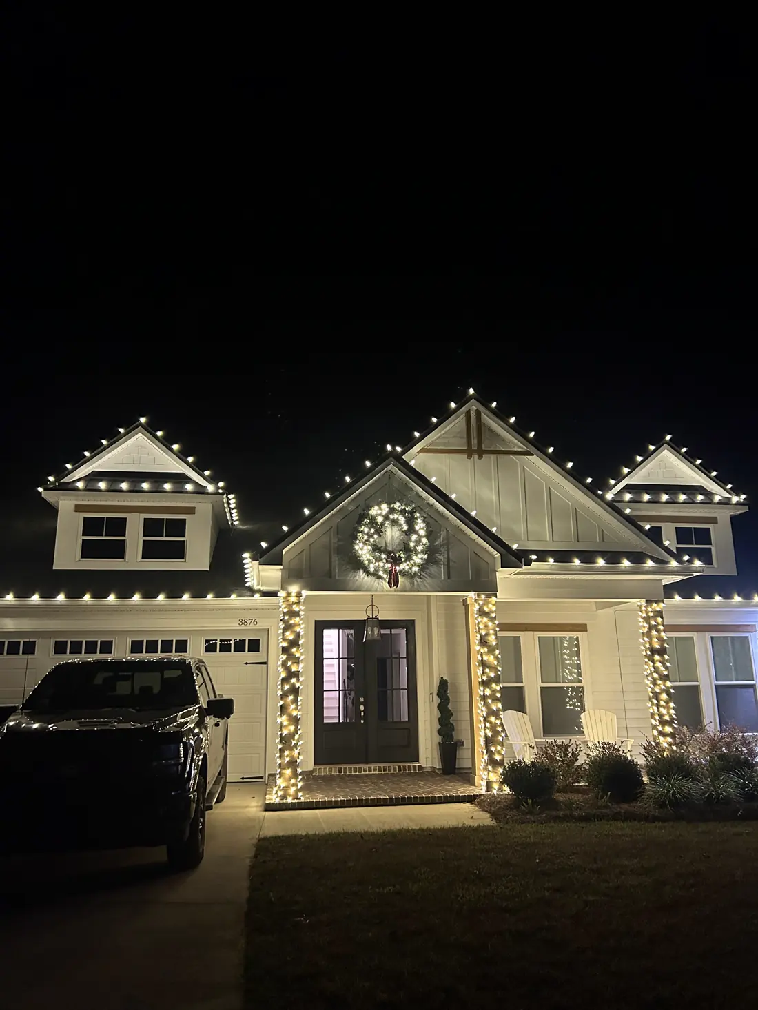 Craftsman home with warm white roofline, wreath and wrapped columns