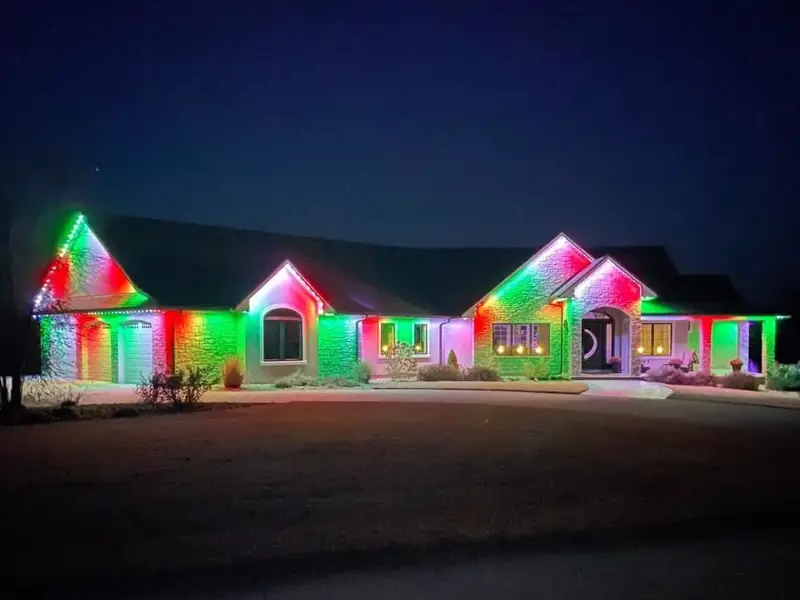 Permanent RGB lighting glowing red and green along a ranch roofline