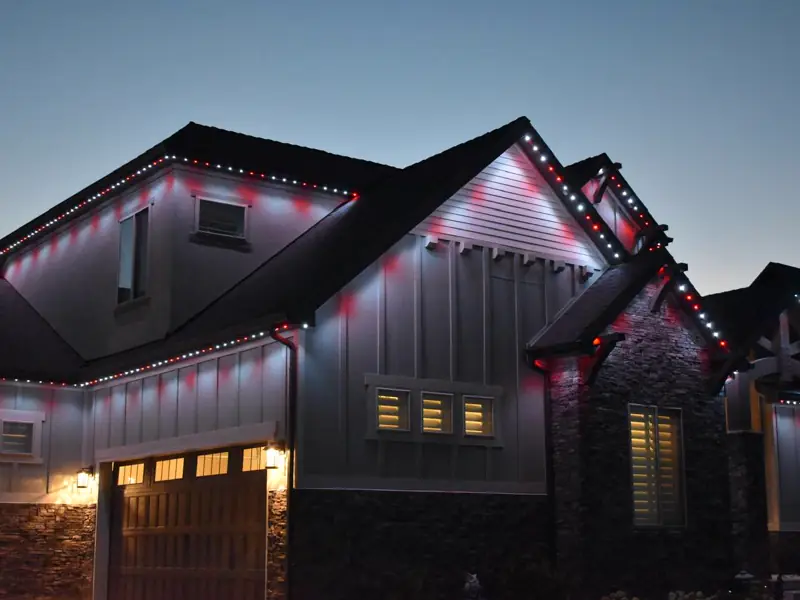 Permanent RGB lighting on a modern farmhouse at dusk