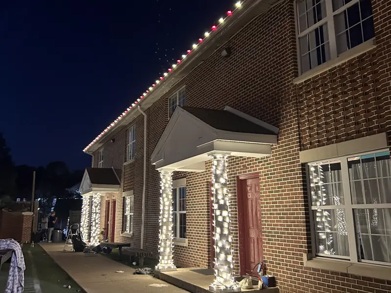 Warm white roofline and wrapped porch columns on brick townhomes